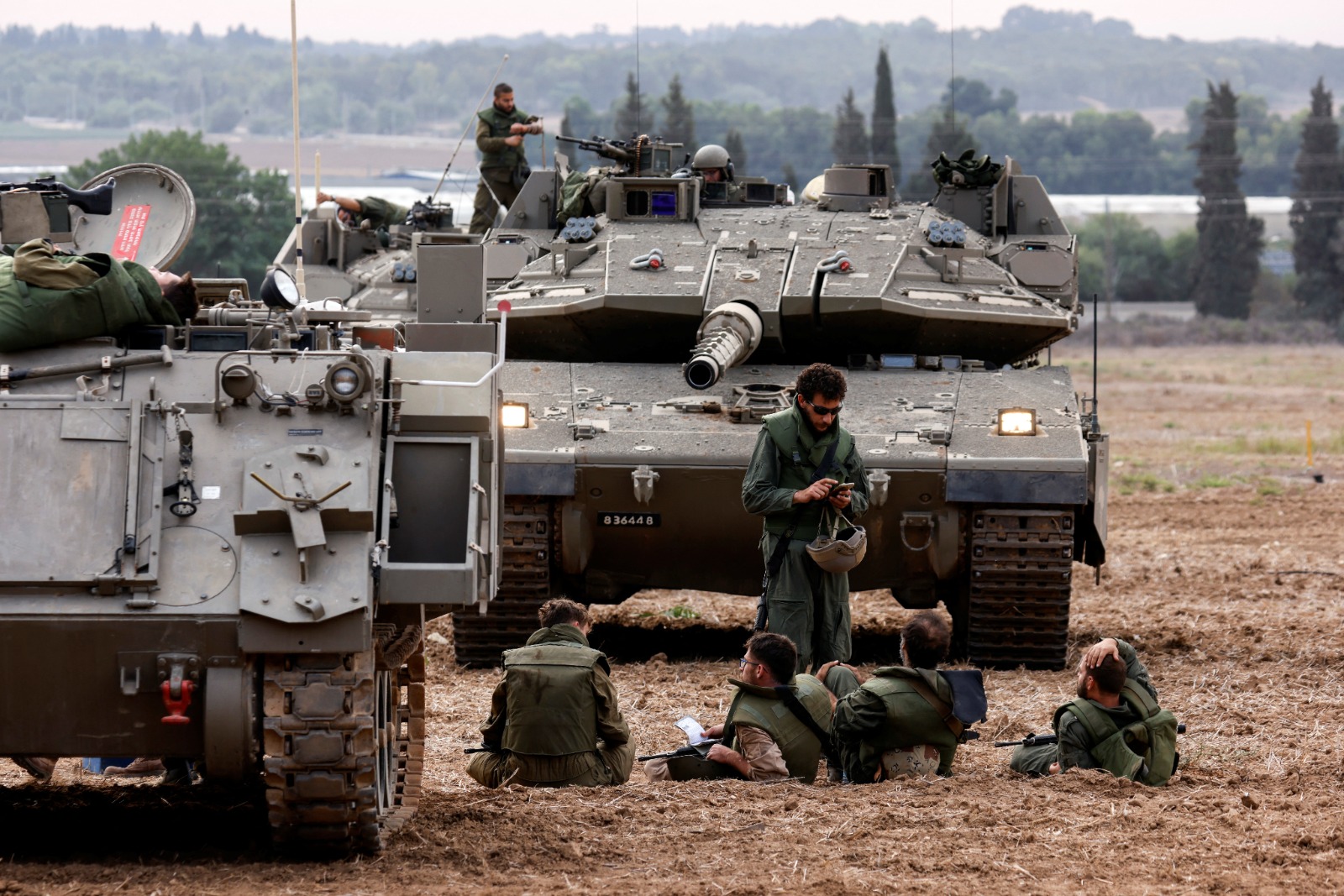جنود إسرائيليون بجانب دبابات قرب الحدود مع قطاع غزة، 9 أكتوبر 2023