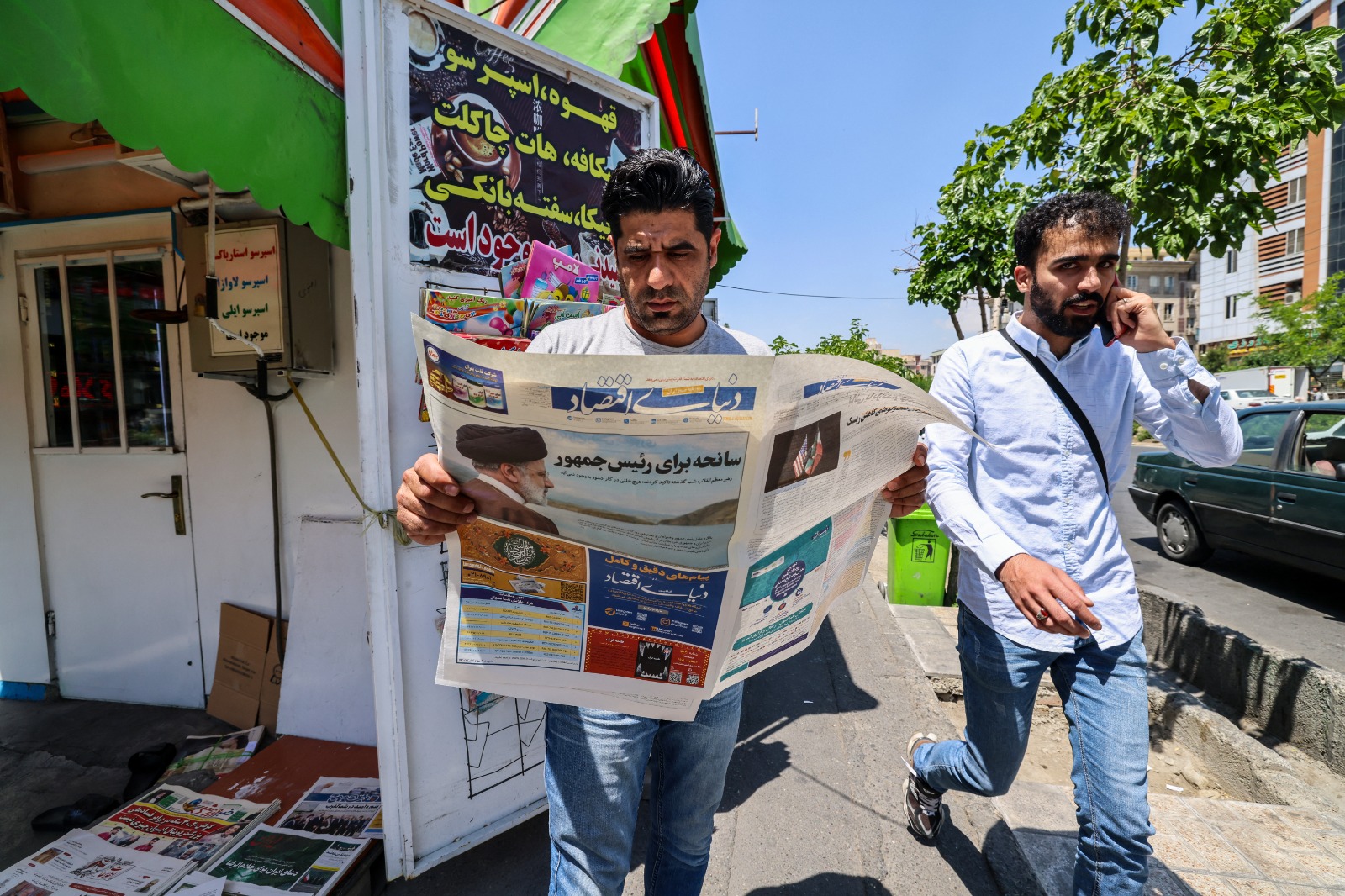 رجل يقرأ صحيفة تحتوي على تقرير في الصفحة الأولى عن تحطم مروحية الرئيس الإيراني. طهران، إيران. 20 مايو 2024.