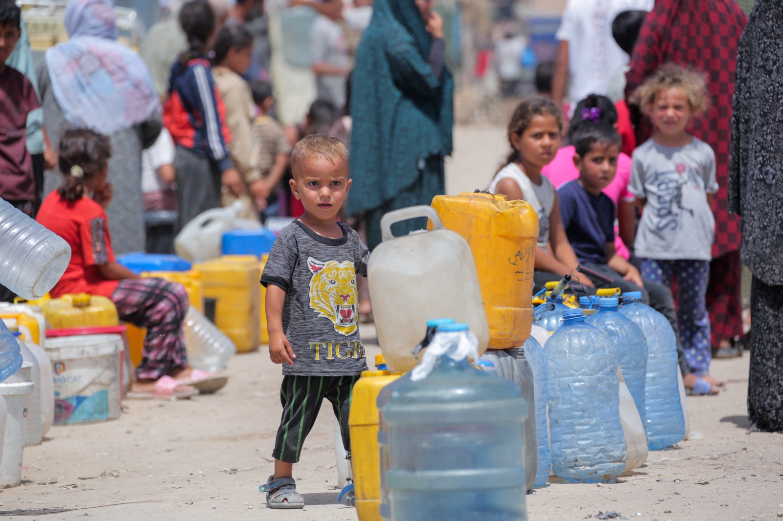 أطفال فلسطينيون نازحون يصطفون للحصول على المياه في رفح جنوب قطاع غزة. 19 مايو 2024