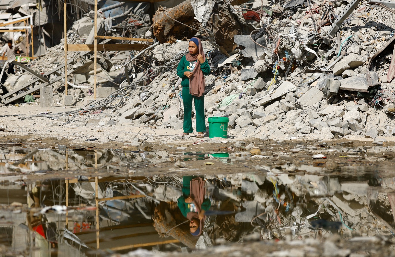 فتاة فلسطينية تقف بجوار أنقاض مبان مدمرة في مدينة غزة. 2 نوفمبر 2025