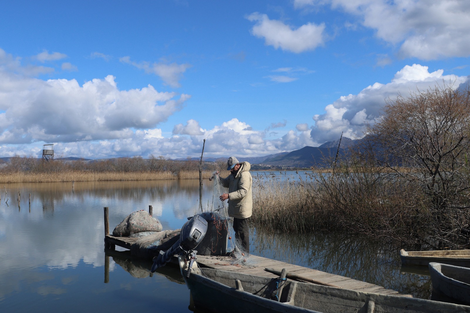 صياد يجهز شبكته للصيد في بحيرة فاين في ألبانيا. 13 مارس 2024