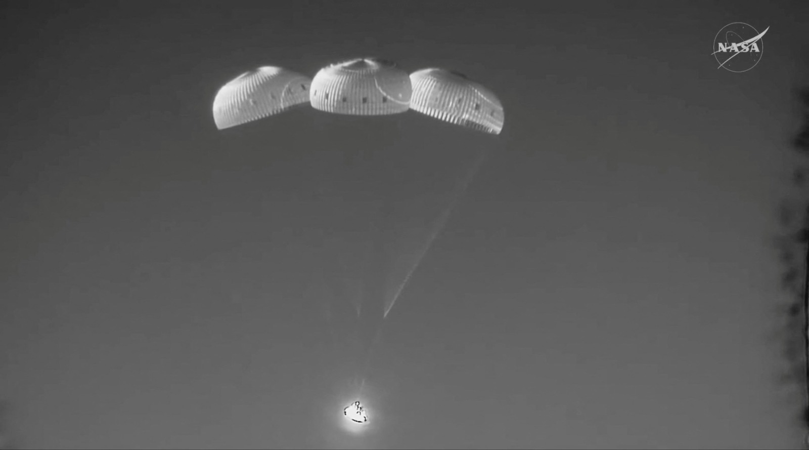 ثلاث مظلات رئيسية تُفتح على متن كبسولة طاقم أرتميس 2 أثناء توجهها نحو منطقة الهبوط في المحيط بعد عودتها إلى الأرض عقب تحليق طاقم أرتميس 2 بالقرب من القمر. 10 أبريل 2026