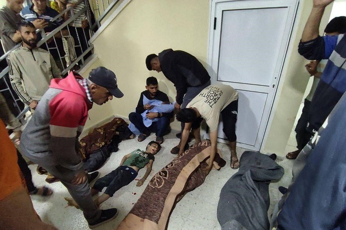 فلسطينيون مصابون يفترشون أرضية مستشفى شهداء الأقصى بدير البلح بسبب نقص القدرة السريرية لاستيعابهم