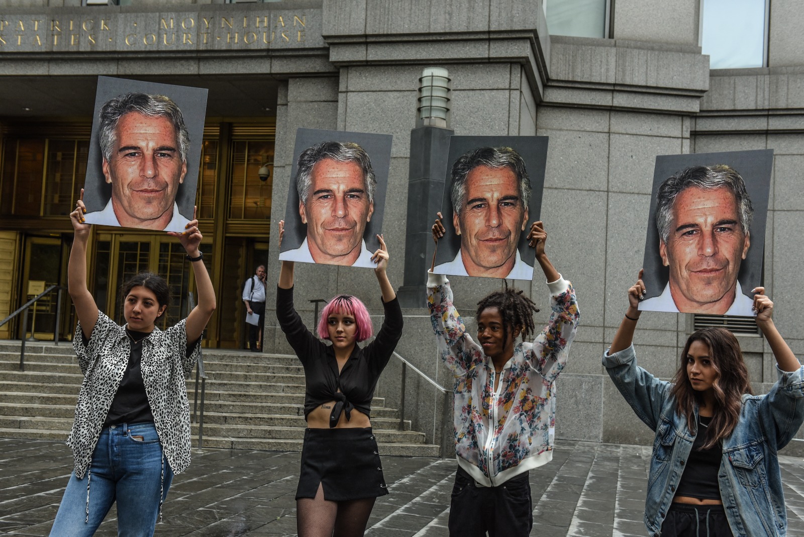 محتجون يرفعون صور جيفري إبستين أمام المحكمة الفدرالية في نيويورك قبل محاكمته. 8 يوليو 2019