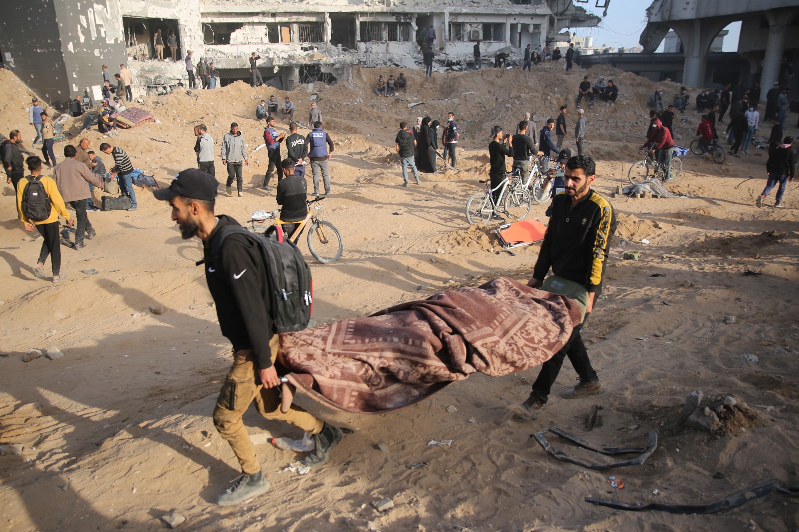 فلسطينيون يحملون جثة مغطاة في مستشفى الشفاء بغزة بعد انسحاب الجيش الإسرائيلي من المجمع. 1 أبريل 2024