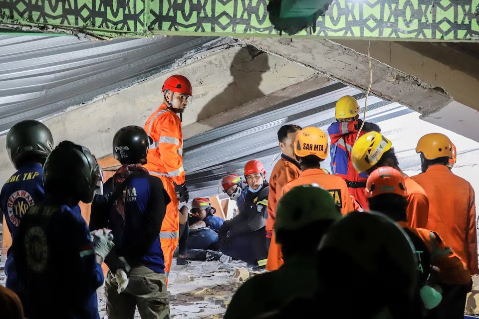 رجال إنقاذ يبحثون عن ضحايا تحت أنقاض مدرسة انهارت أثناء أداء صلاة العصر في منطقة جاوة الشرقية، إندونيسيا، 29 سبتمبر 2025