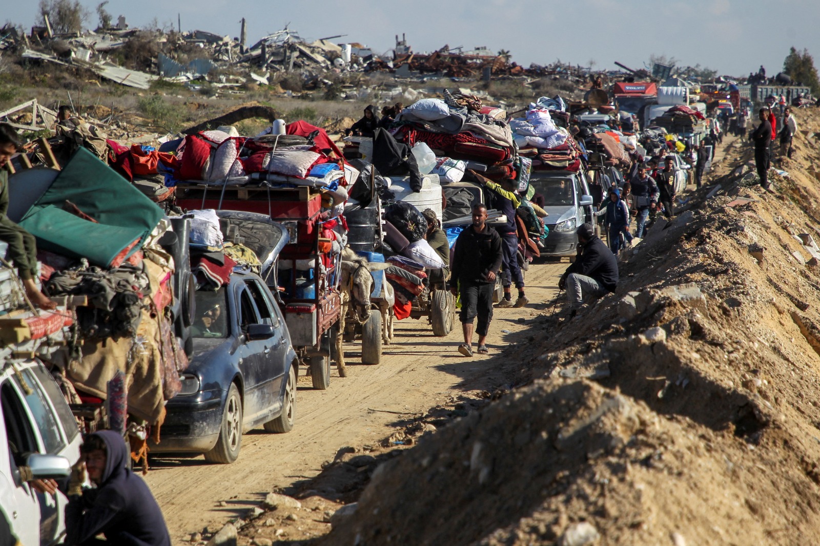 فلسطينيون ينتظرون تفتيش مركباتهم أثناء عودتهم إلى منازلهم في شمال قطاع غزة. 27 يناير 2025