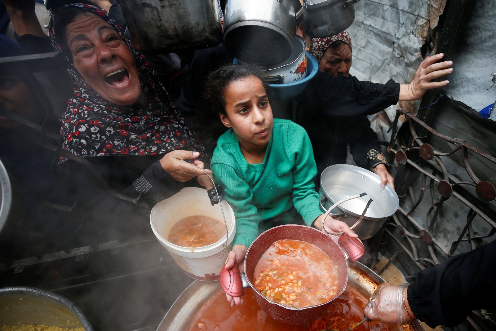 فلسطينيون يتلقون طعاماً أعدته جمعية خيرية في بيت لاهيا بشمال قطاع غزة. 28 أبريل 2025