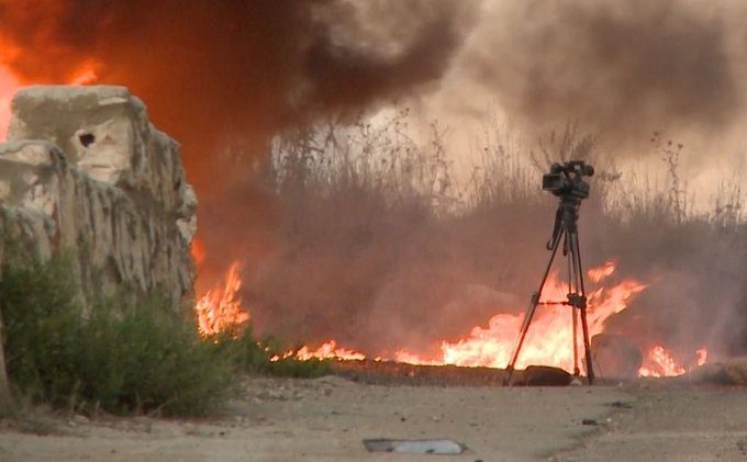 صورة سيارة طاقم قناة الجزيرة تشتعل فيها النيران بعدما تعرضت للقصف بالقرب من قرية علما الشعب.