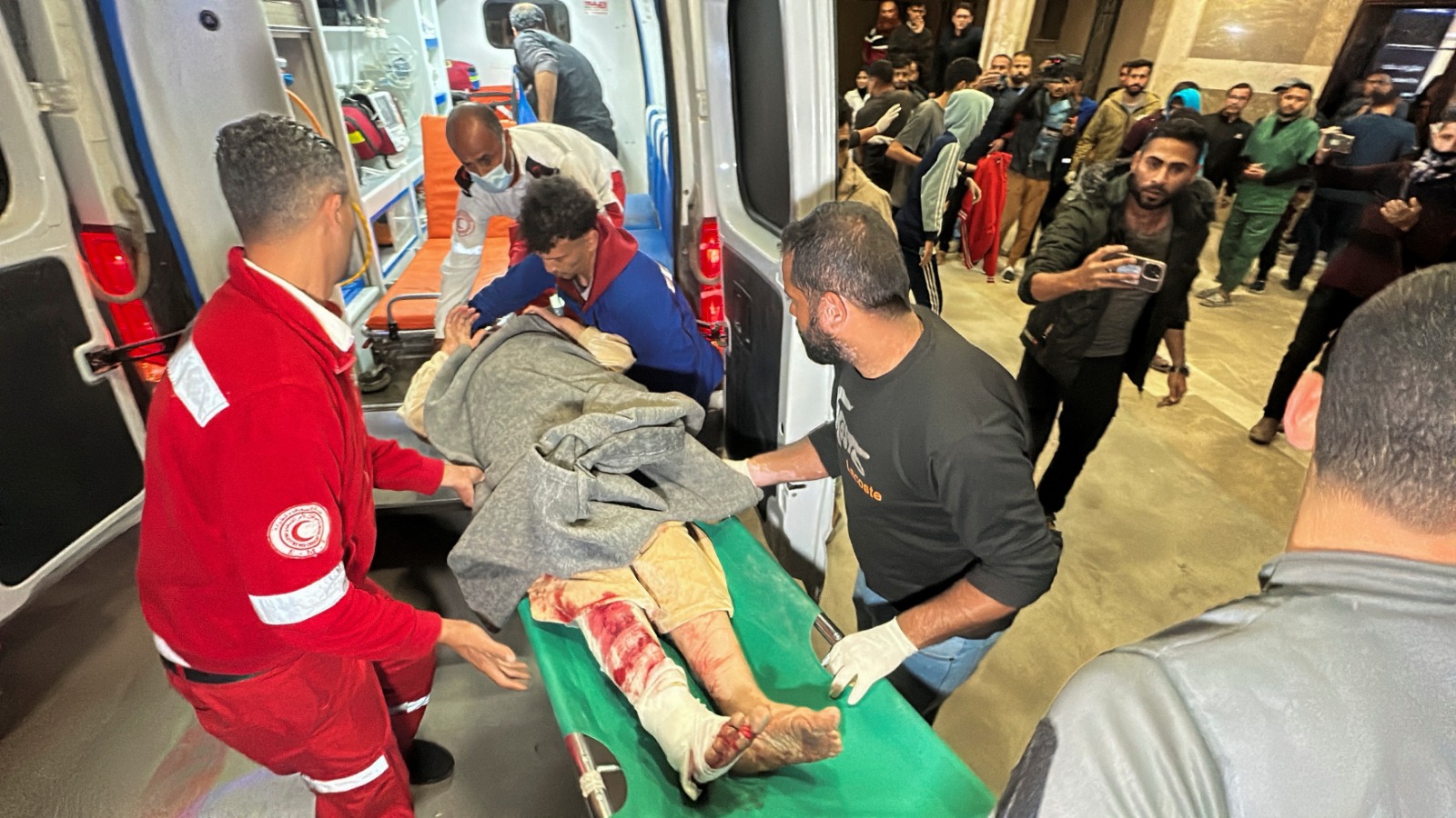 مسعفون ينقلون مصاباً فلسطينياً إلى مستشفى ناصر في خان يونس جنوب قطاع غزة بعد شن إسرائيل غارات واسعة على القطاع. 18 مارس 2025