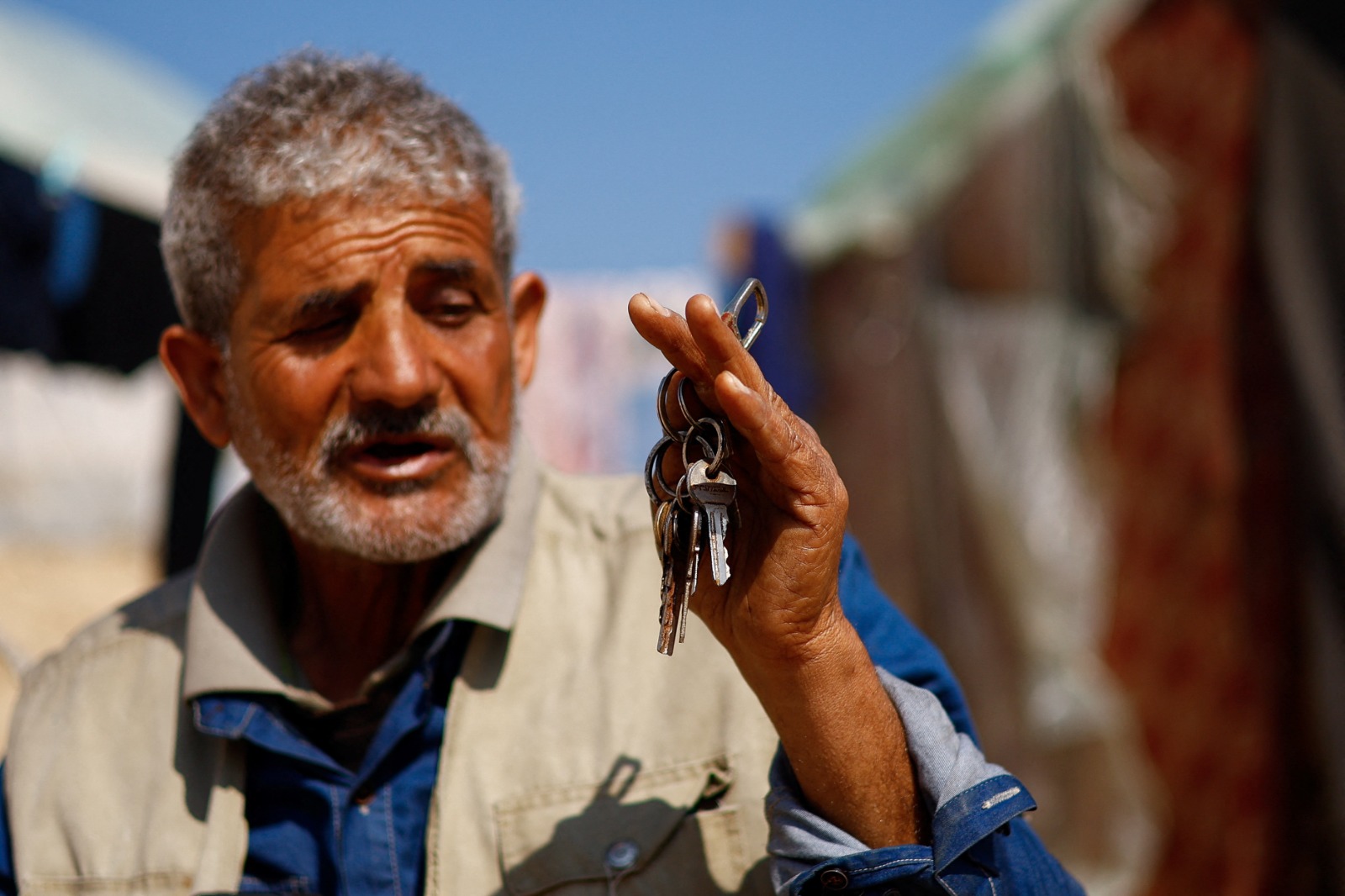 فلسطيني دمرت غارات إسرائيلية منزله وسط الصراع المستمر بين إسرائيل وحماس، يحمل مفاتيح منزله المدمر، خارج خيمته في رفح، جنوب قطاع غزة. 26 فبراير 2024