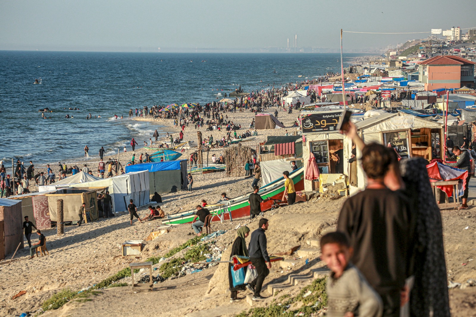 فلسطينيون ترحوا خيام النزوح لقضاء الوقت على شاطئ البحر في دير البلح بقطاع غزة، 17 أبريل 2024