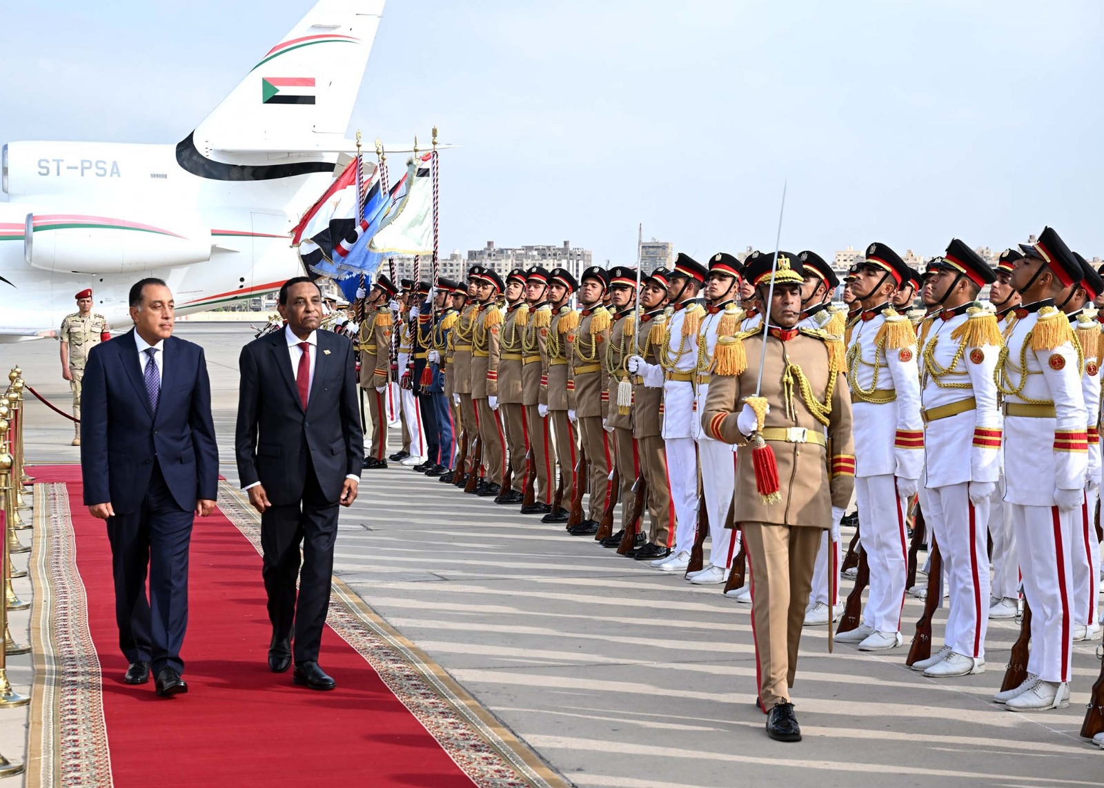 رئيس الوزراء المصري مصطفى مدبولي خلال استقبال نظيره السوداني كامل إدريس في مطار القاهرة الدولي. 7 أغسطس 2025