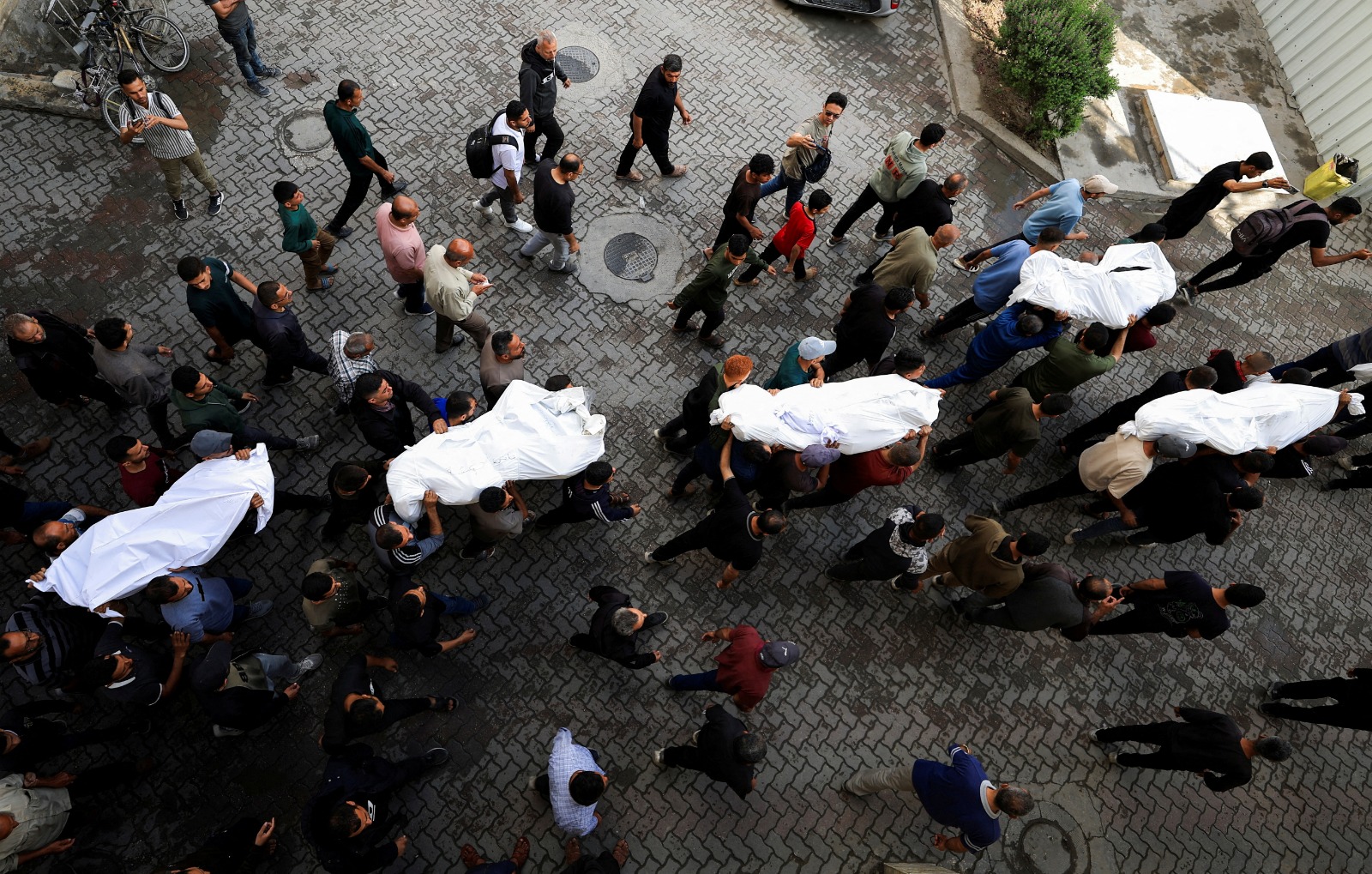 يحمل المشيعون جثامين الفلسطينيين الذين قتلوا في الغارات الإسرائيلية  في مستشفى الأهلي العربي في مدينة غزة. 20 مايو 2025