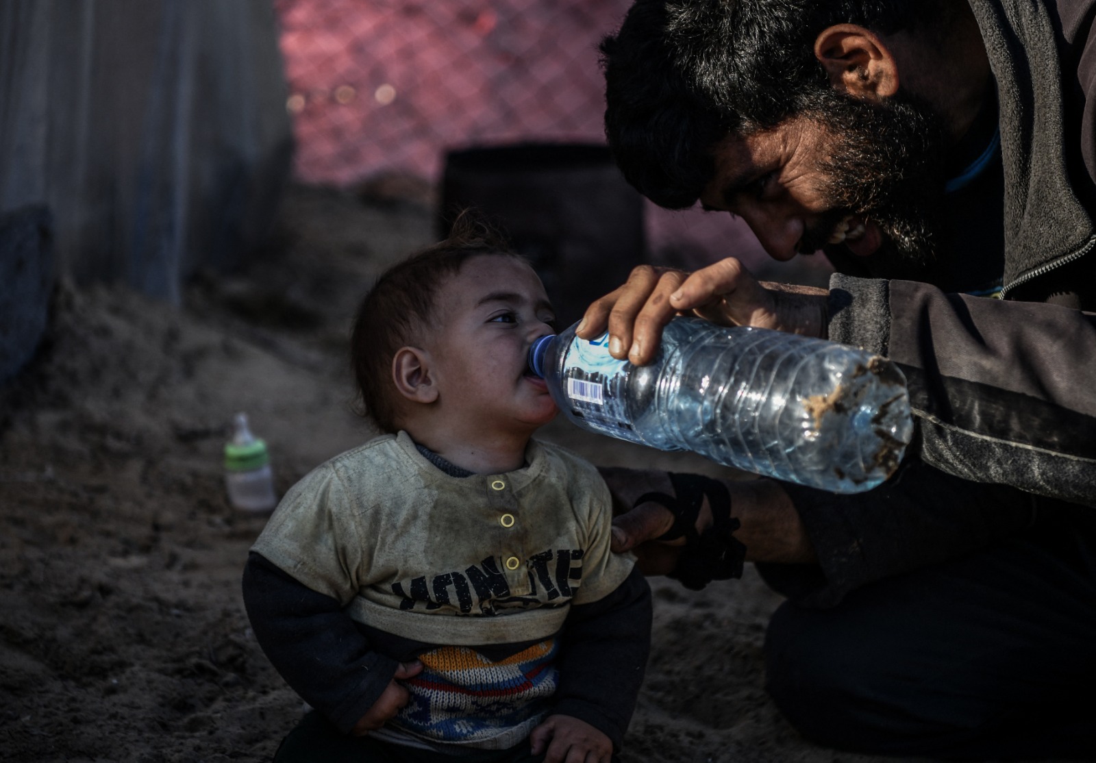 طفل فلسطيني يشرب الماء وسط كفاح النازحين من أجل العثور على مياه نظيفة في رفح، جنوب قطاع غزة. 9 فبراير 2024