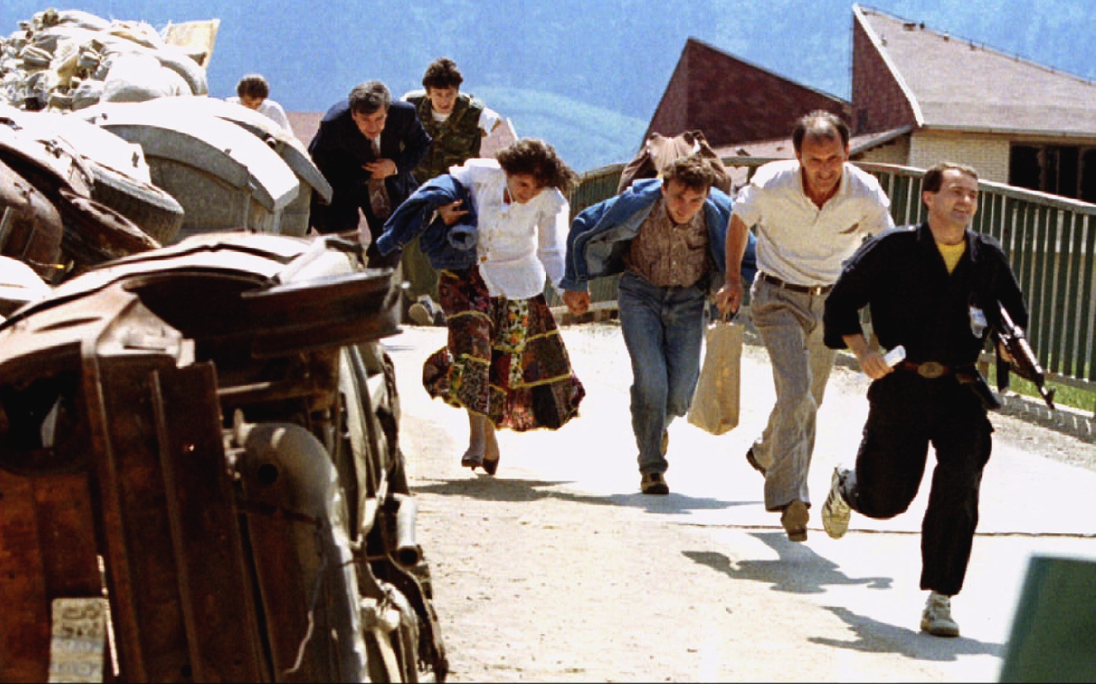 مواطنون بوسنيون مع رجل شرطة يحاولون الاحتماء من نيران القناصة في العاصمة البوسنية سراييفو. 2 يونيو 1993