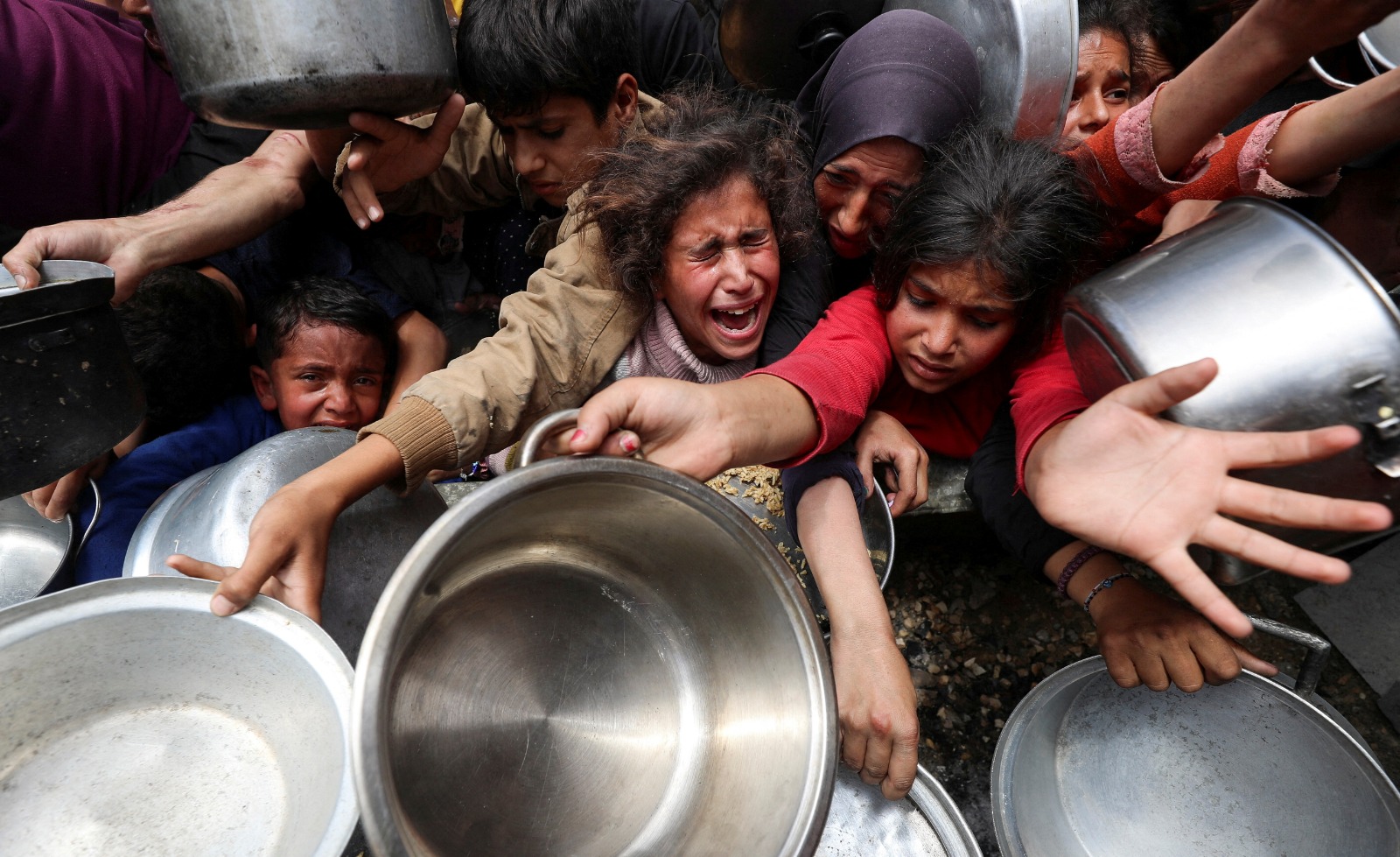 فلسطينيون ينتظرون الحصول على طعام من مطبخ خيري في جباليا، شمال قطاع غزة. 14 مايو 2025