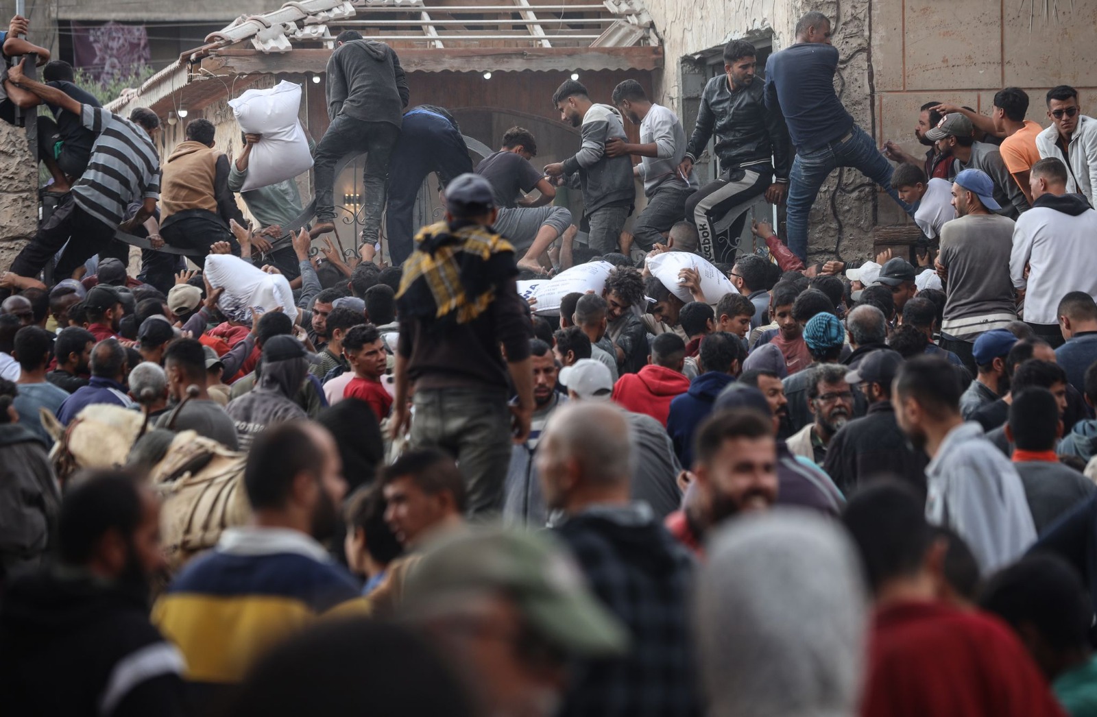 فلسطينيون يحتشدون للحصول على مساعدات إنسانية تقدمها وكالة الأونروا في دير البلح بوسط غزة بينما يتواصل القصف الإسرائيلي على القطاع. 3 نوفمبر 2024