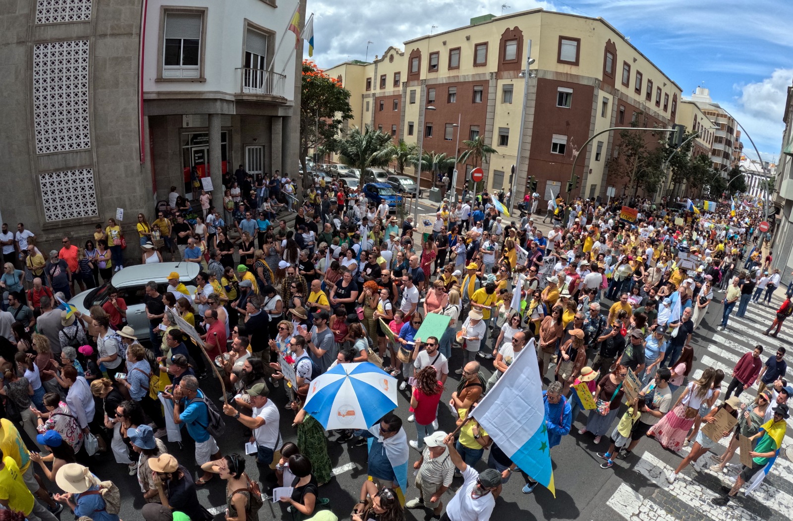 أشخاص يسيرون في أحد الشوارع خلال مظاهرة من أجل تغيير نموذج السياحة في جزر الكناري، في سانتا كروز دي تينيريفي، إسبانيا. 20 أبريل، 2024