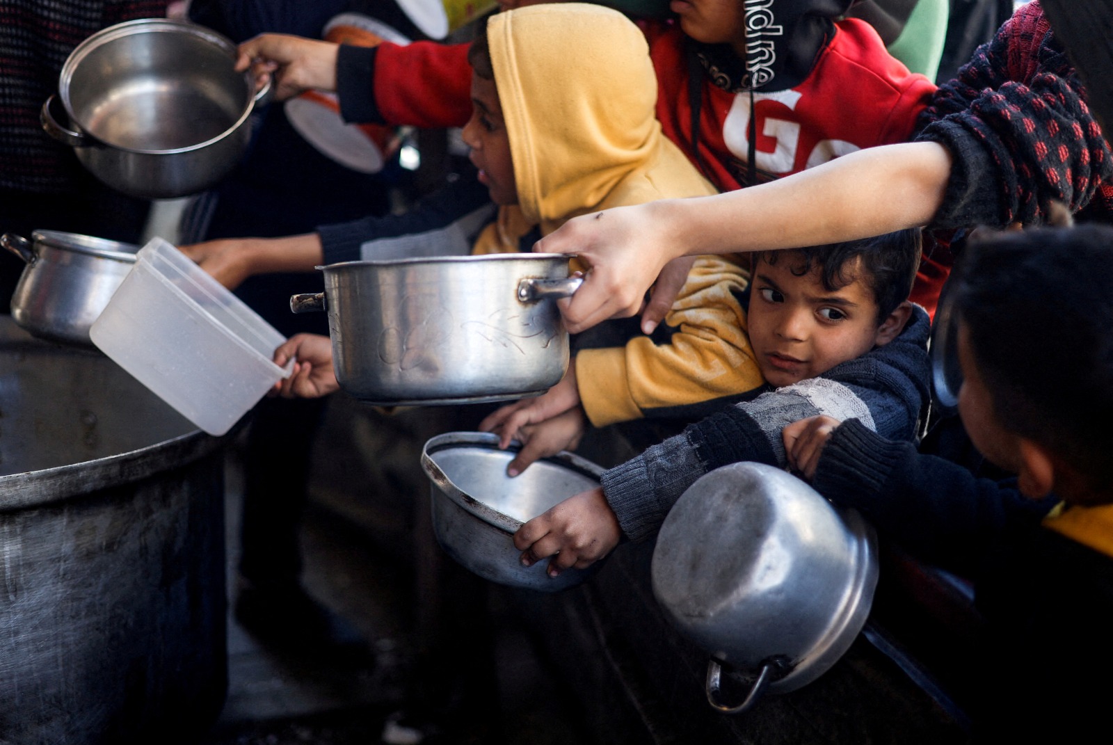 أطفال فلسطينيون ينتظرون الحصول على طعام من أحد المطابخ الخيرية في رفح جنوب قطاع غزة. 5 مارس 2024