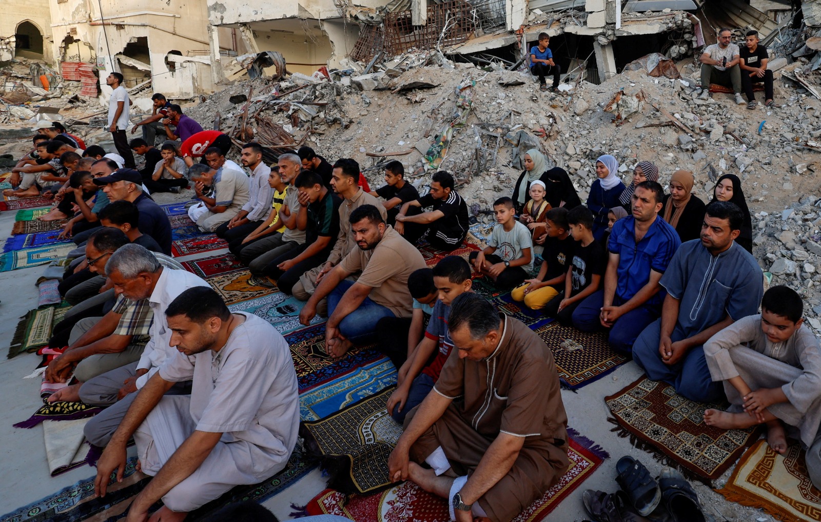 فلسطينيون يؤدون صلاة عيد الأضحى على أنقاض مسجد الرحمة الذي دمرته غارات جوية إسرائيلية في خان يونس جنوب قطاع غزة. 16 يونيو 2024