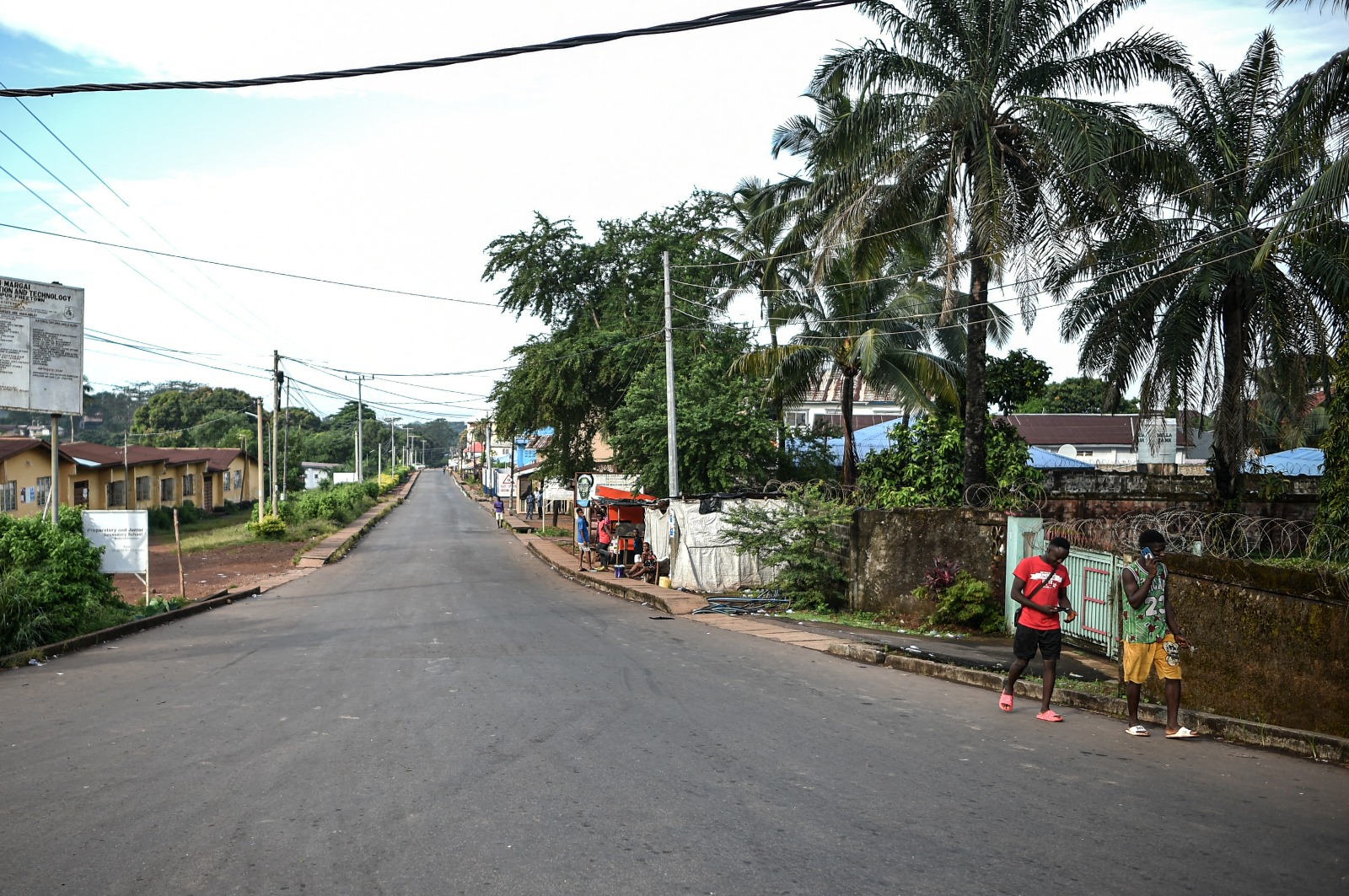 رجلان يسيران في في أحد الطرقات الخالية بعد حظر تجول في فريتاون عاصمة سيراليون. 26 نوفمبر 2023