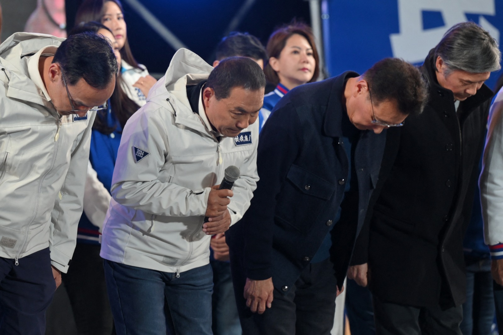 مرشح حزب المعارضة الرئيسي كومينتانج هو يو-إيه (الثاني من اليسار) ينحني بجانب نائبه جو شو كونج (الثاني من اليمين) أثناء إقرارهما بالهزيمة في الانتخابات الرئاسية في تايبيه بتايوان. 13 يناير 2024 - AFP