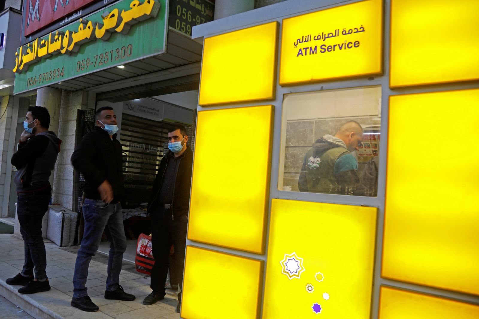 موظفو السلطة الفلسطينية ينتظرون استلام رواتبهم خارج أحد البنوك في الضفة الغربية المحتلة. 3 ديسمبر 2020